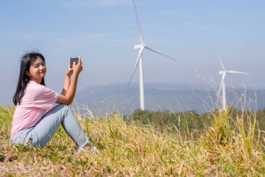 Genç kız dağın tepesinde dikiliyor güzel manzara manzarasını seyrediyor ve Khao Yai Thieng Elektrik Türbininde rüzgar türbini Tayland.