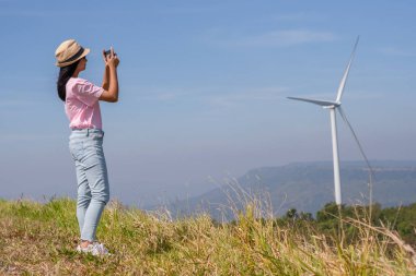 Genç kız dağın tepesinde dikiliyor güzel manzara manzarasını seyrediyor ve Khao Yai Thieng Elektrik Türbininde rüzgar türbini Tayland.