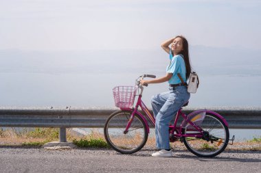 Genç kız, rüzgar türbini, Khao Yai Thieng elektrikli rüzgar türbini Tayland ile dağda bisiklet sürüyor..