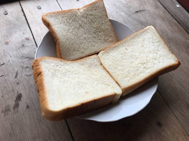 Bread on wooden background. Rustic rye. Fresh loaf of rustic traditional bread on wooden texture background. Bakery with crusty loaves. Design element for bakery product label, design, and etc