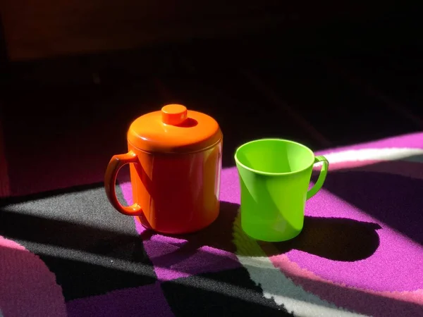 杯橙色和绿色与垫紫色背景 漂亮的杯子 — 图库照片