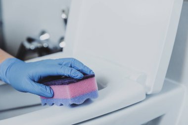 Plastik koruyucu eldivenli kadın eli eldiveni. Ev hanımı tuvalet temizleme kabı, deterjanlı koltuk, banyoda ya da umumi tuvalette pembe bez. Dezenfeksiyon, hijyen, temizlik hizmeti