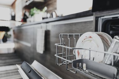 Yemekten sonra kirli aletlerle modern ev mutfağının içinde otomatik paslanmaz bulaşık makinesi açılacak. Ev işleri, ev işleri. Ev işleri, günlük rutin işler.