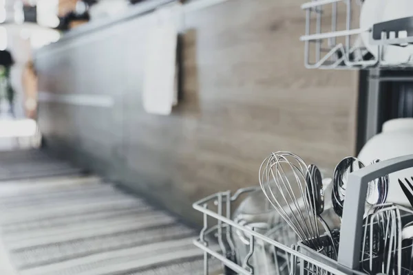 在现代化的家庭厨房里 用干净的器皿把打开的自动不锈钢内置式洗碗机封闭起来 洗衣机的开启和关闭 带厨房用具的室内生活方式 — 图库照片