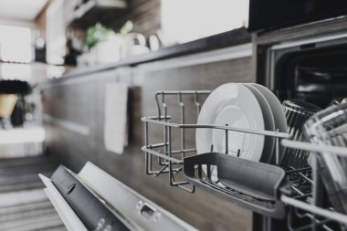 Modern ev mutfağındaki temiz aletlerle birlikte otomatik paslanmaz bulaşık makinesinin kapağını kapatın. Ev işleri, ev işleri. Çamaşır makinesinin açılıp kapatılması