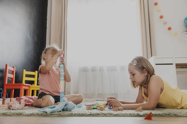 カラフルな木製のおもちゃ列車で遊んでいる子供たち 子供たちは 自宅の寝室 幼稚園 保育室 遊び場 遊び場でカーペットの上に座っています 子供のための面白い教育環境に優しいゲーム — ストック写真