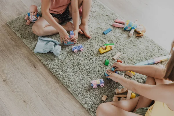 カラフルな木製のおもちゃ列車で遊んでいる子供たち 子供たちは 自宅の寝室 幼稚園 保育室 遊び場 遊び場でカーペットの上に座っています 子供のための面白い教育環境に優しいゲーム — ストック写真