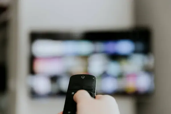 Tangan Memegang Remote Control Menunjuk Orang Yang Menonton Televisi Cerdas Stok Gambar Bebas Royalti