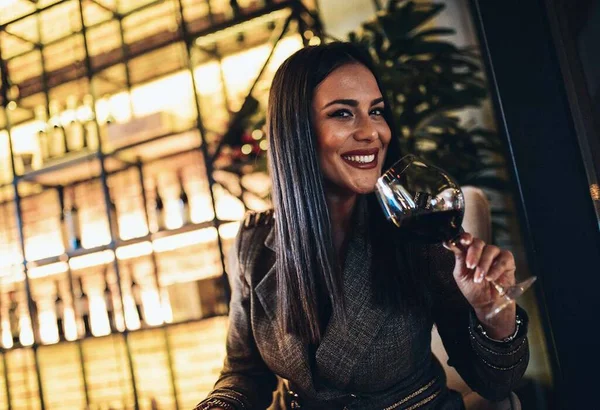 stock image Smiling woman having wine at bar 