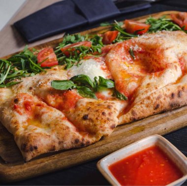 Pizza Patty namı diğer Çedar Peyniri ve Sosisli Calzone Tahta Tabakta