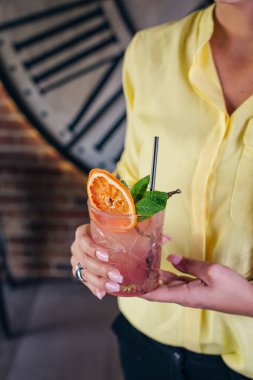 Kadın kokteyli elinde tutuyor. Kokteyl içiyorum. Kokteyl barı