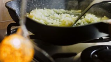 Doğranmış soğanı tavada kızart. Yakın plan çekimde soğan kızart. Kızarmış soğan kalorisi sağlık yardımları ve zararları.