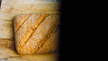 Çizgileri olan taze pişmiş kare ekmek. Arka planda romantik bir ortam var. Kahverengi arka planda münferit bir ekmek çeşidi. Kaydırıcı atışı.