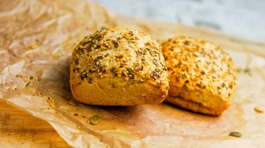 İki taze kare somun ekmek ve kabak çekirdeği. Arka planda romantik bir çevre var..