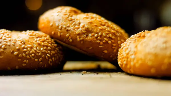 stock image Three loaves of freshly baked bread in a round shape. In the background is a romantic entourage.