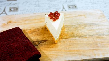 Frenk üzümlü bir dilim peynirli kek. Makro ve kaydırma atışı. Arka planda bir retro atmosfer var..