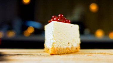 Frenk üzümlü bir dilim peynirli kek. Makro ve kaydırma atışı. Arka planda bir retro atmosfer var..