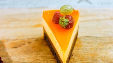 Turuncu şeftali ve çilek reçelli bir dilim pasta. Makro ve kaydırma atışı. Arka planda bir retro atmosfer var..