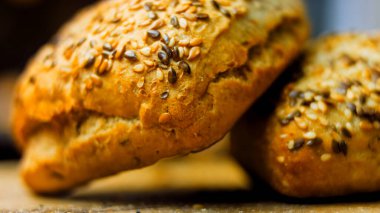 İki taze kare somun ekmek ve kabak çekirdeği. Arka planda romantik bir çevre var..