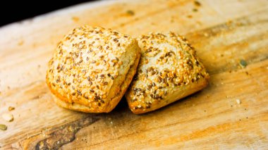 İki taze kare somun ekmek ve kabak çekirdeği. Arka planda romantik bir çevre var..