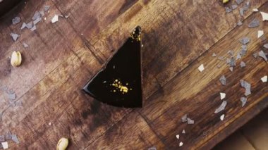 Tahta tepside altın tozuyla süslenmiş muzlu çikolatalı pasta..