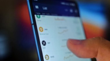 Caucasian male making a payment with bitcoins cryptocurrency using his smartphone. Custom application interface design. Light rays effect.