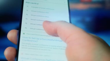 Looking at the smartphone, questions about the virtual conference.