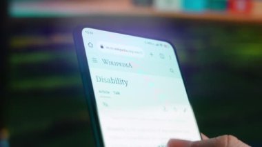 Looking at the smartphone, I read information about disability.