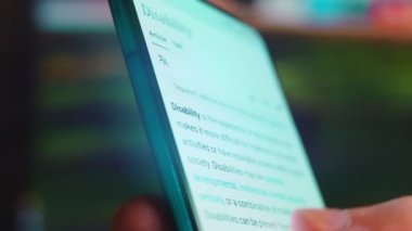 Looking at the smartphone, I read information about disability.