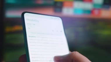 Looking at the smartphone, I read information about disability.