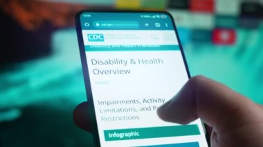 Looking at the smartphone, I read information about disability.