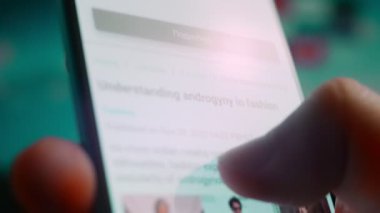 Looking at the smartphone, I read information about androgynous.
