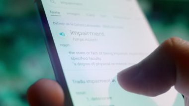 Looking at the smartphone, I read information about impairment.