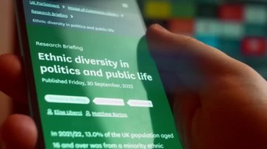 Looking at the smartphone, I read information about minorities in politics.