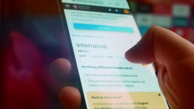 Looking at the smartphone, I read information about interracial.