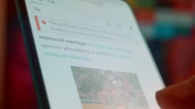 Looking at the smartphone, I read information about interracial.