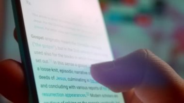 Looking at the smartphone, I read information about the gospel.