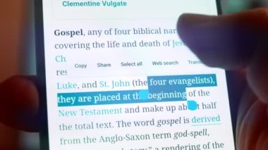 Looking at the smartphone, I read information about the gospel.