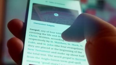 Looking at the smartphone, I read information about the gospel.