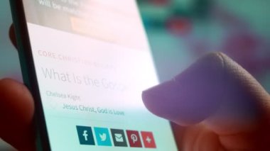 Looking at the smartphone, I read information about the gospel.