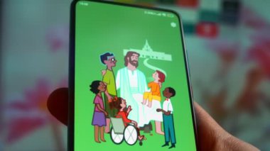 Looking at the smartphone, application about the gospel.