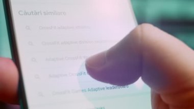 Smartphone in hand, macro view of the adaptive athlete question.