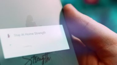 Smartphone in hand, macro view of the stay at home question.