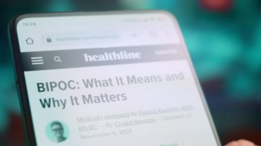 Smartphone in hand, macro view of the bipoc question.