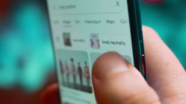 Smartphone in hand, macro view of the body positive question.