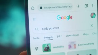 Smartphone in hand, macro view of the body positive question.