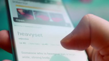 Smartphone in hand, macro view of the heavyset question.