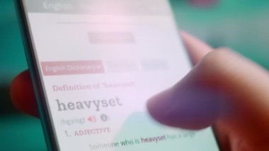 Smartphone in hand, macro view of the heavyset question.