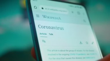 Smartphone in hand, looking for information about the coronavirus.