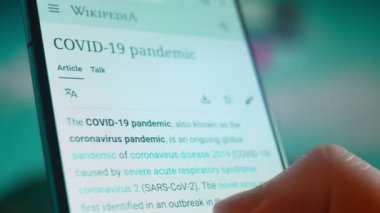 Smartphone in hand, looking for information about the coronavirus.